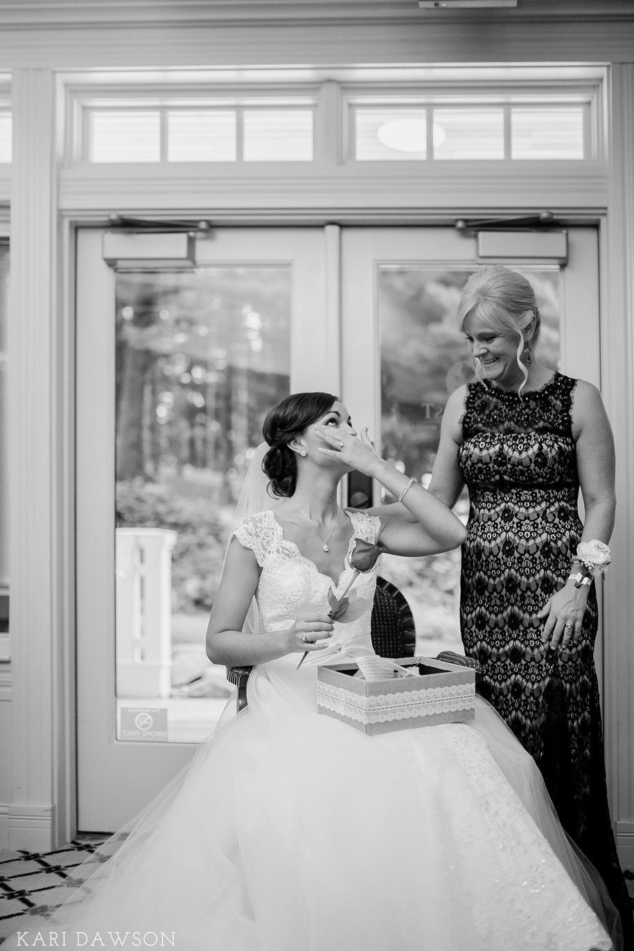 A tender moment as the bride opens her gift from her groom l black tie country club wedding l rustic elegance