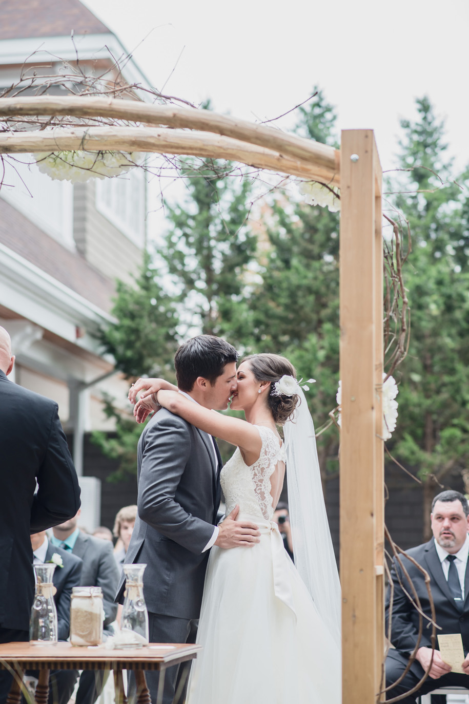 Rustic twig and branch arbor for a rustic elegant outdoor ceremony in the woods l Lace wedding dress and tulle skirt l Tuxedo l Bow tie l First Kiss