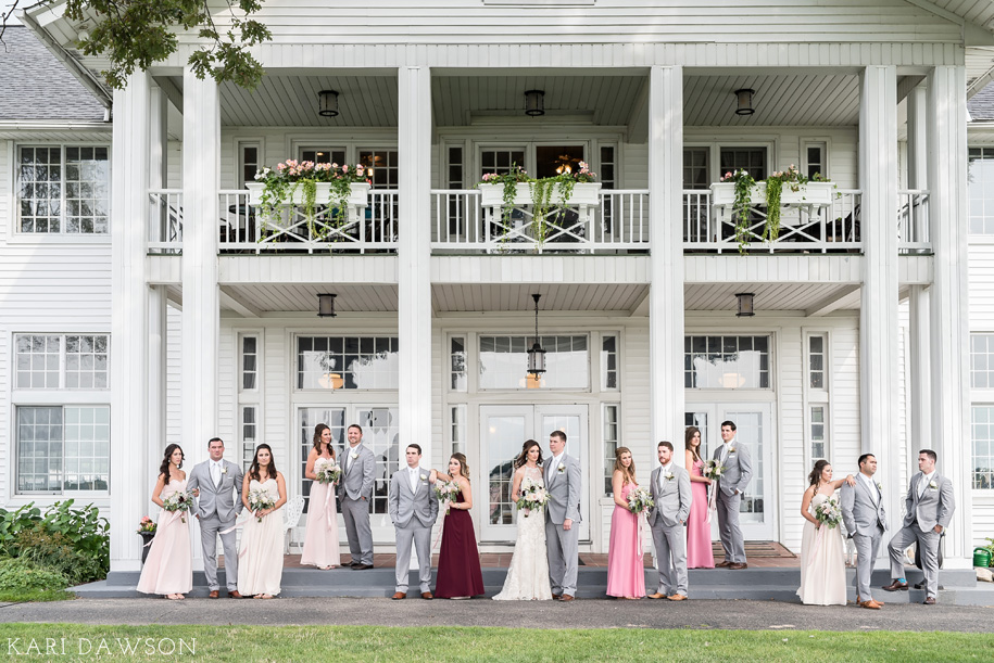 Fun bridal party pose l Rustic summer wedding with bridesmaids in pinks and wines and groomsman in gray with white ties l Romantic Waldenwoods Wedding