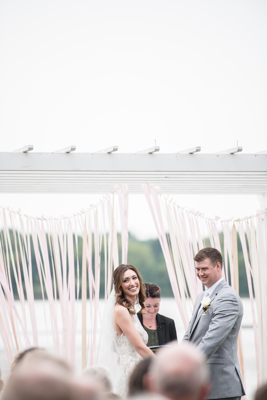 The ribbons swaying in the wind at the altar for this outdoor wedding ceremony is gorgeous. Made extra special by this giggling bride.