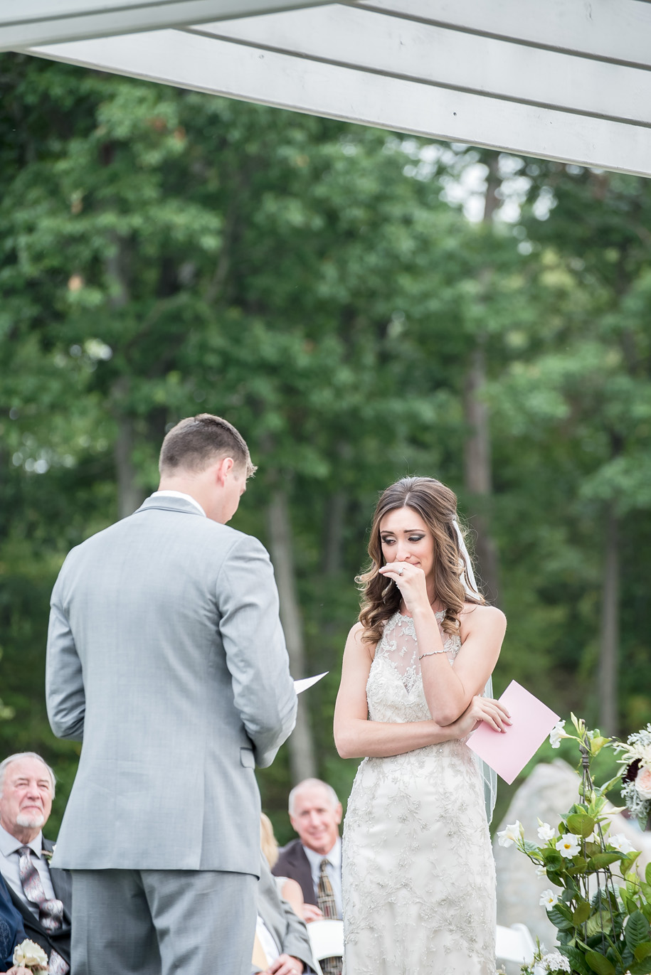 Sweet moment of a bride as her groom reads his vows l Rustic outdoor wedding ceremony l Pink and gray wedding