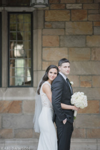 Elegant and timeless lace bodice wedding dress designed by the bride and her groom in an elegant and classic black suit and black tie at the University of Michigan Law Quad by Kari Dawson Photography