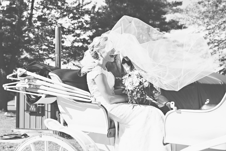 The cutest candid moment on their wedding day in the horse drawn carriage . An elegant H Hotel wedding in Midland Michigan by Kari Dawson