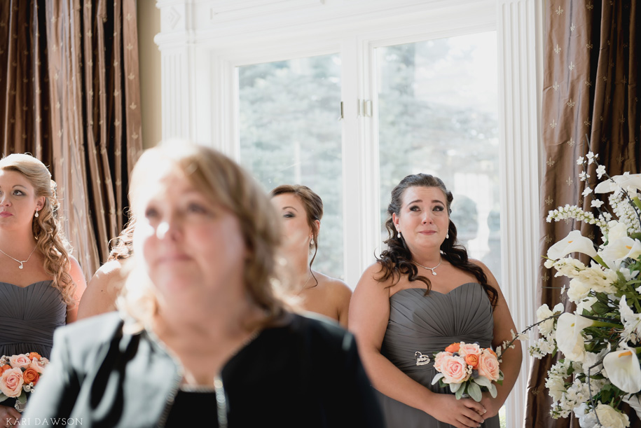 Made of Honor and best friend shed happy tears as the bride comes down the aisle at this fall wedding in Michigan by Kari Dawson