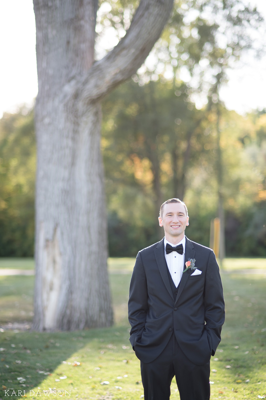 Classic Groom Portrait on his wedding day in his traditional black tuxedo and blow tie . An Autumn Wedding Chapel Wedding in Michigan