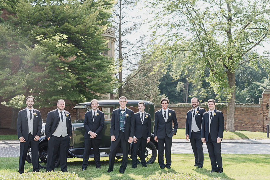 The groom's scottish tartan vest really pops in front of his classic model T at Meadow Brook Hall. Colorful Meadow Brook Mansion wedding in Rochester, Michigan provided by Kari Dawson, top-rated Rochester, Michigan wedding photographer, and her team. 