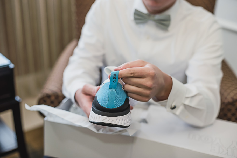 The perfect wedding day gift from a bride to her groom who loves his sneakers!! Sage and navy summer wedding at the Detroit Athletic Club in Detroit, Michigan provided by Kari Dawson, top-rated Detroit wedding photographer, and her team.