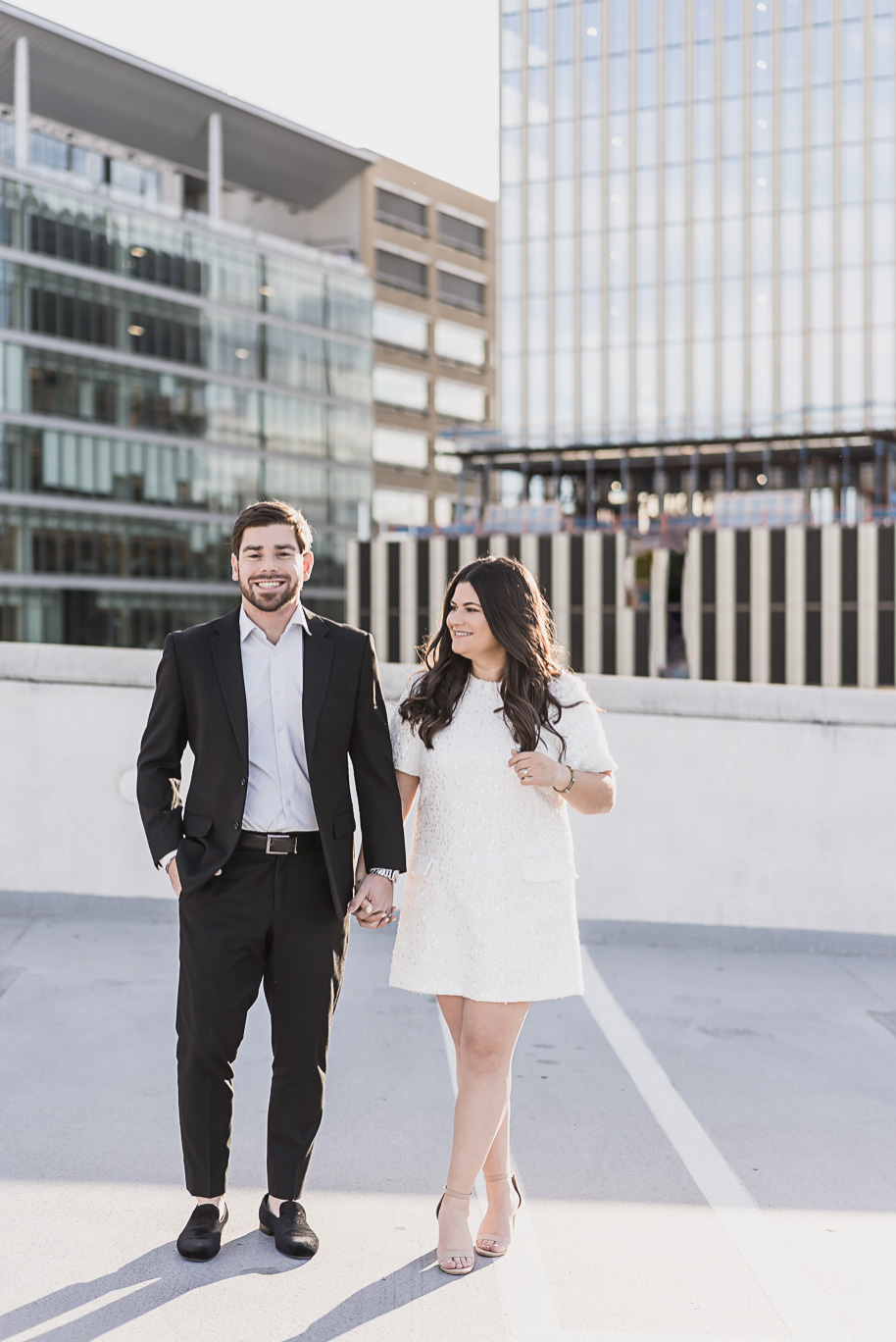 Couple walking hand-in-hand on the Z Lot rooftop in Detroit for their downtown Detroit Engagement Photos by Kari Dawson