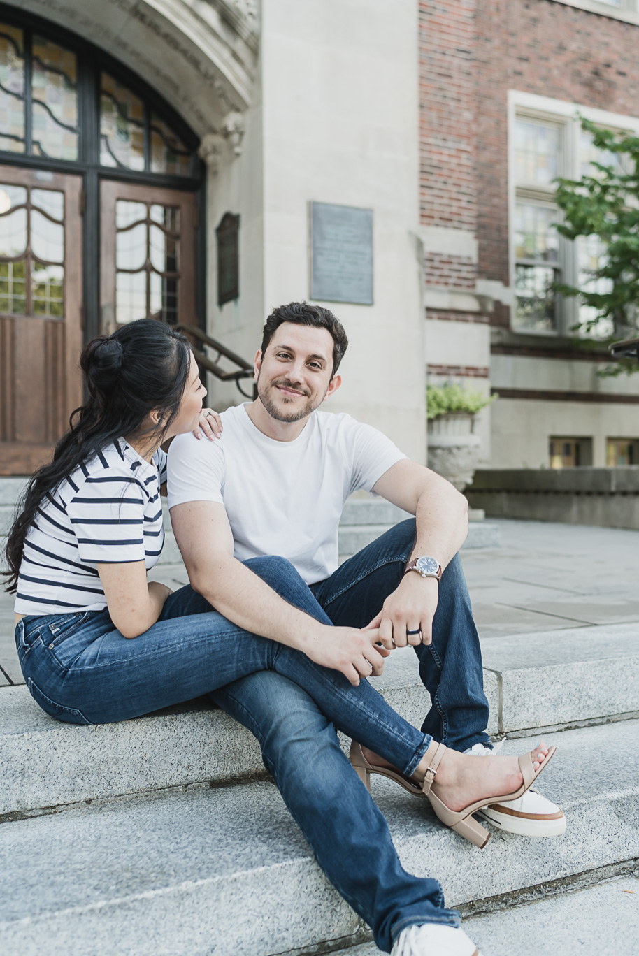 Relaxed University of Michigan engagement photo of couple sitting on iconic campus steps, captured with timeless and romantic style.