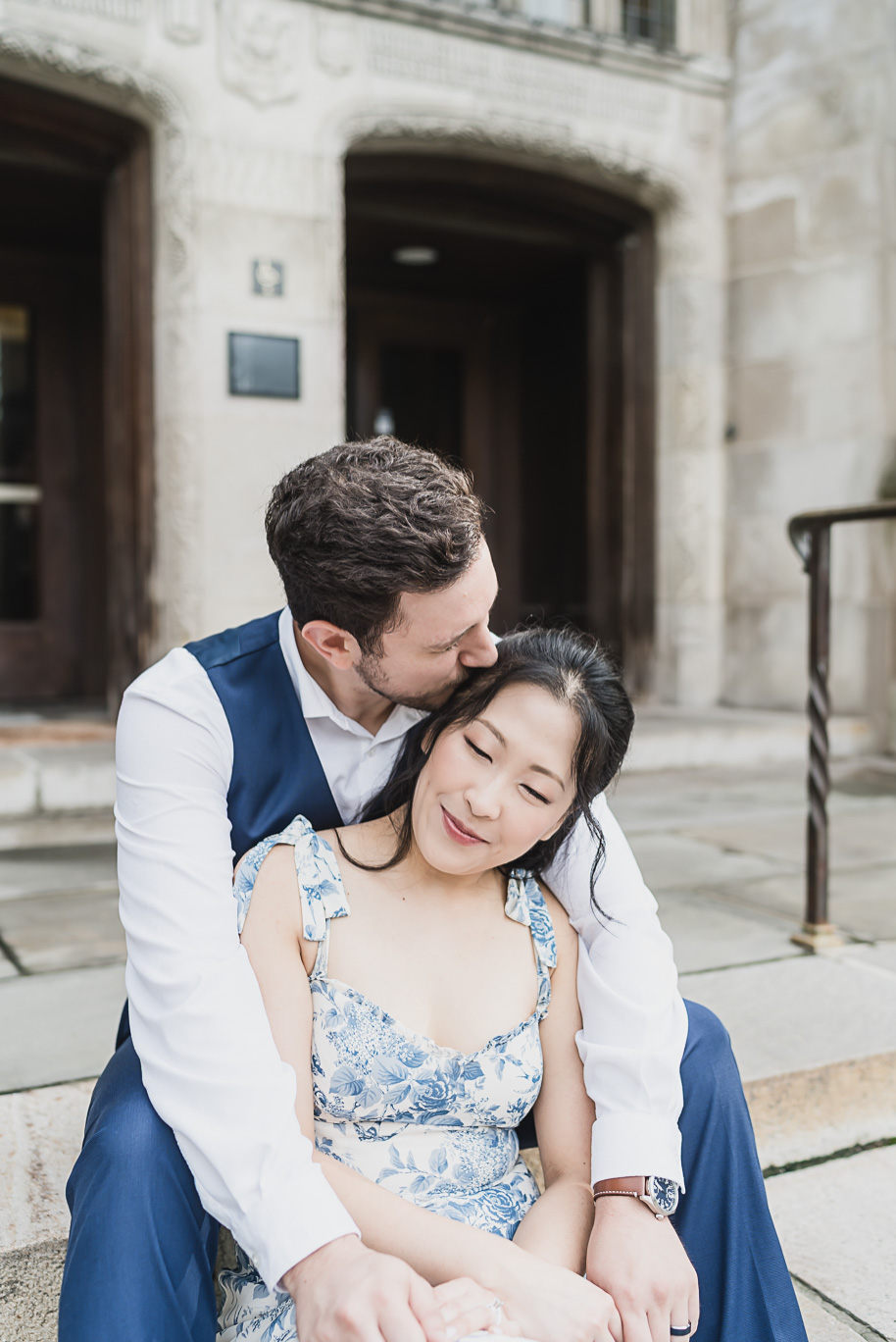 Intimate Michigan Law Quad engagement photo where Alex kisses Linda’s forehead while she smiles softly, capturing love and elegance in Ann Arbor.