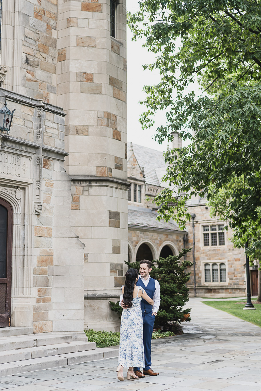 Romantic Michigan Law Quad engagement session with couple embracing under historic stone architecture at the University of Michigan, photographed by top Ann Arbor wedding photographer Kari Dawson.
