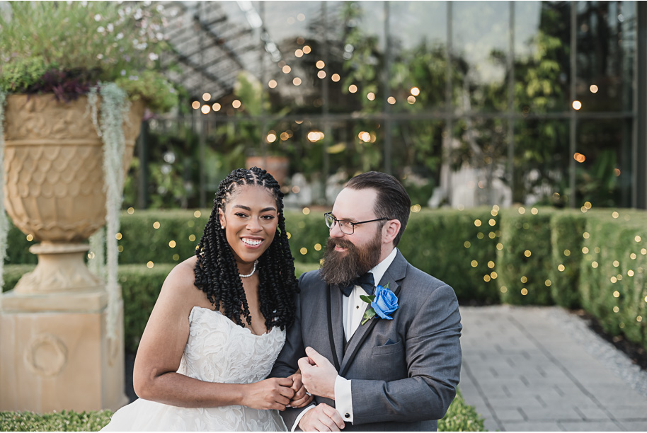An elegant fall Planterra Conservatory wedding captured by Kari Dawson + Co in Bloomfield Hills, Michigan. This Euro-inspired greenhouse celebration featured lush floral design, golden candlelight, and heartfelt vows beneath the glass canopy. Perfect inspiration for couples dreaming of a romantic Michigan wedding surrounded by nature and timeless architecture.
