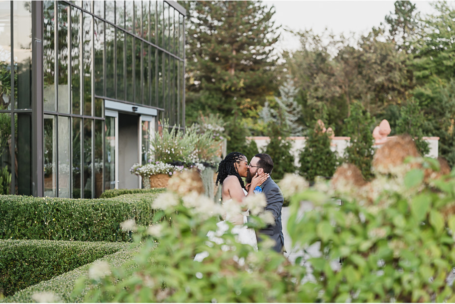 An elegant fall Planterra Conservatory wedding captured by Kari Dawson + Co in Bloomfield Hills, Michigan. This Euro-inspired greenhouse celebration featured lush floral design, golden candlelight, and heartfelt vows beneath the glass canopy. Perfect inspiration for couples dreaming of a romantic Michigan wedding surrounded by nature and timeless architecture.