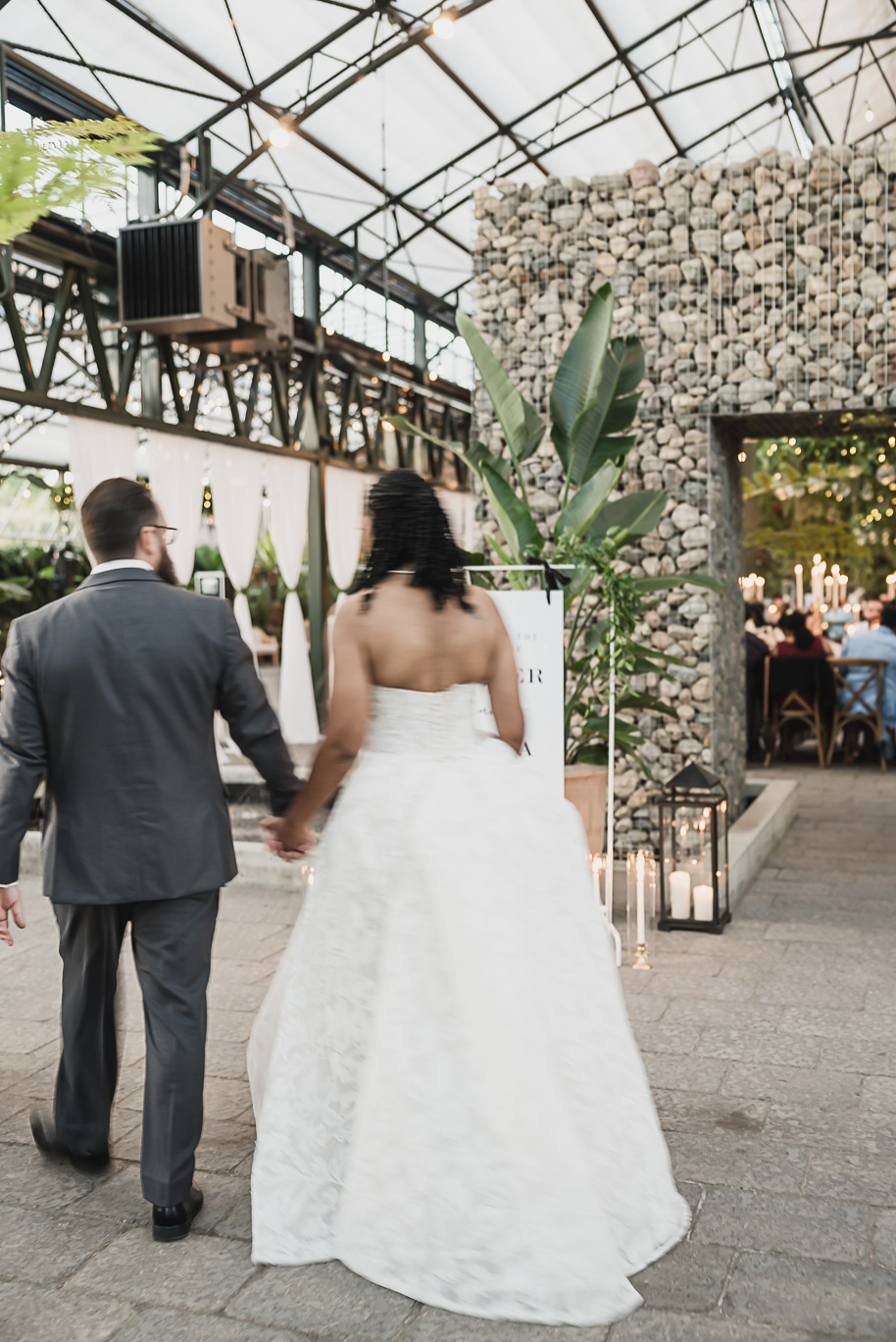 An elegant fall Planterra Conservatory wedding captured by Kari Dawson + Co in Bloomfield Hills, Michigan. This Euro-inspired greenhouse celebration featured lush floral design, golden candlelight, and heartfelt vows beneath the glass canopy. Perfect inspiration for couples dreaming of a romantic Michigan wedding surrounded by nature and timeless architecture.