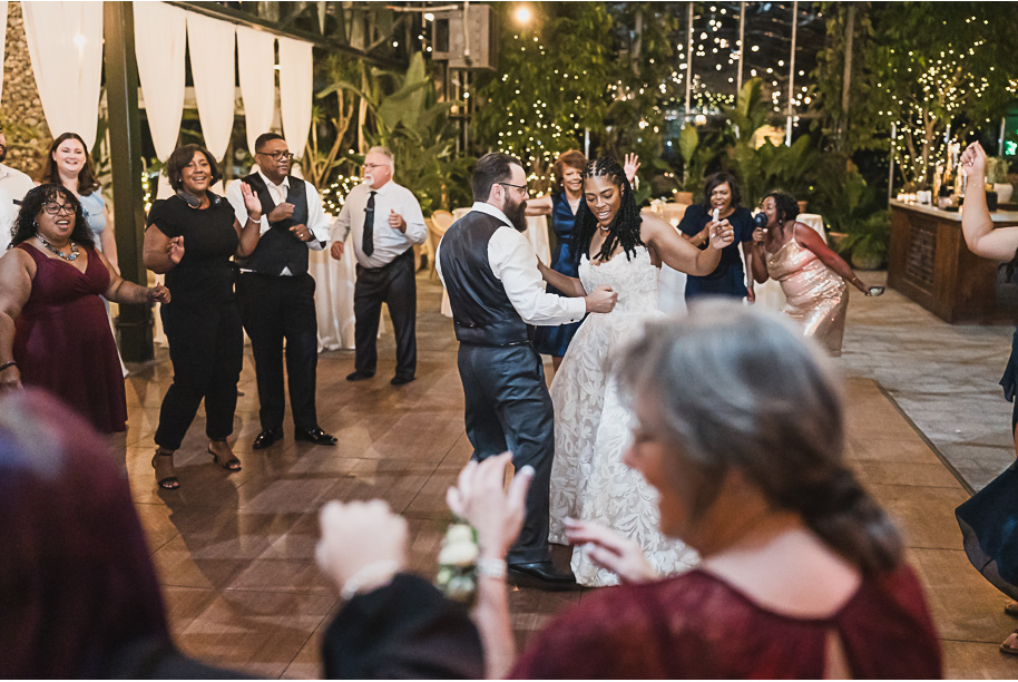 An elegant fall Planterra Conservatory wedding captured by Kari Dawson + Co in Bloomfield Hills, Michigan. This Euro-inspired greenhouse celebration featured lush floral design, golden candlelight, and heartfelt vows beneath the glass canopy. Perfect inspiration for couples dreaming of a romantic Michigan wedding surrounded by nature and timeless architecture.