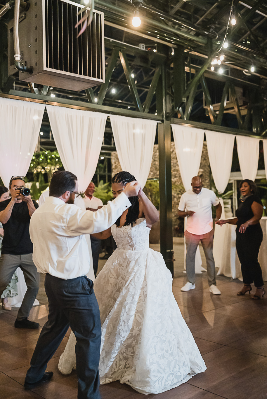 An elegant fall Planterra Conservatory wedding captured by Kari Dawson + Co in Bloomfield Hills, Michigan. This Euro-inspired greenhouse celebration featured lush floral design, golden candlelight, and heartfelt vows beneath the glass canopy. Perfect inspiration for couples dreaming of a romantic Michigan wedding surrounded by nature and timeless architecture.