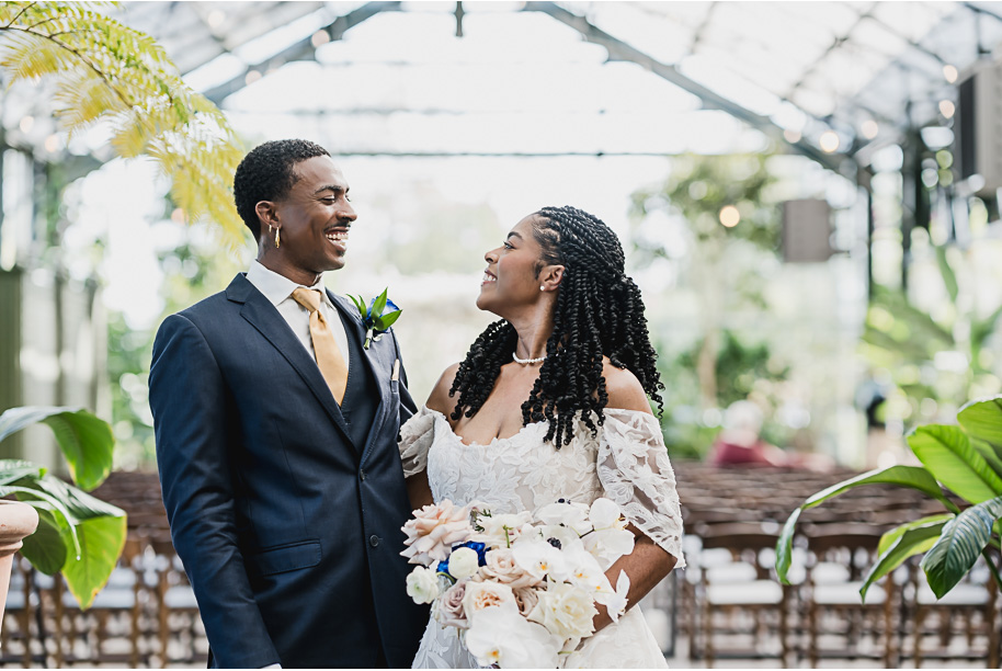 An elegant fall Planterra Conservatory wedding captured by Kari Dawson + Co in Bloomfield Hills, Michigan. This Euro-inspired greenhouse celebration featured lush floral design, golden candlelight, and heartfelt vows beneath the glass canopy. Perfect inspiration for couples dreaming of a romantic Michigan wedding surrounded by nature and timeless architecture.