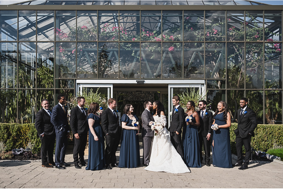 An elegant fall Planterra Conservatory wedding captured by Kari Dawson + Co in Bloomfield Hills, Michigan. This Euro-inspired greenhouse celebration featured lush floral design, golden candlelight, and heartfelt vows beneath the glass canopy. Perfect inspiration for couples dreaming of a romantic Michigan wedding surrounded by nature and timeless architecture.