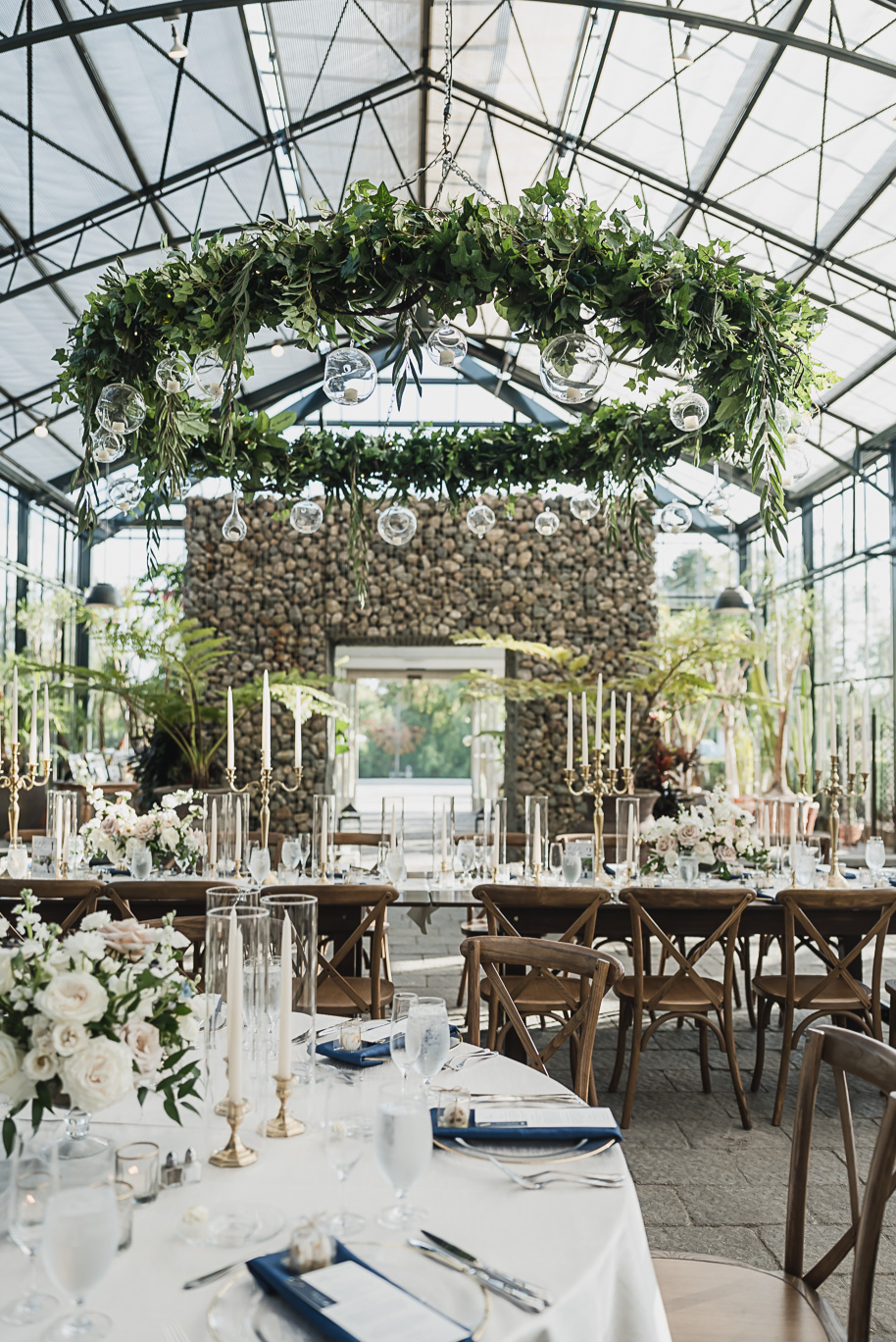 An elegant fall Planterra Conservatory wedding captured by Kari Dawson + Co in Bloomfield Hills, Michigan. This Euro-inspired greenhouse celebration featured lush floral design, golden candlelight, and heartfelt vows beneath the glass canopy. Perfect inspiration for couples dreaming of a romantic Michigan wedding surrounded by nature and timeless architecture.
