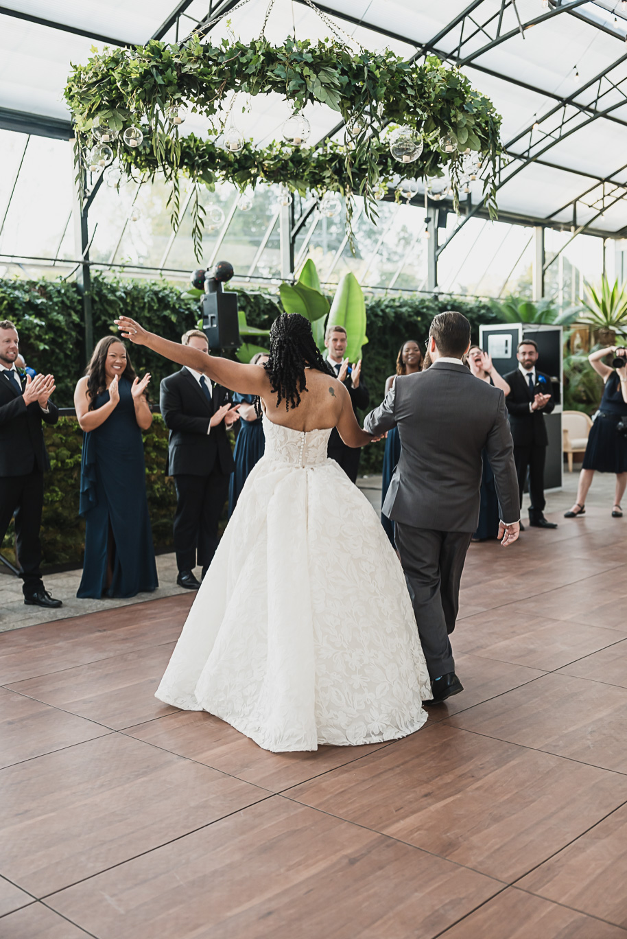 An elegant fall Planterra Conservatory wedding captured by Kari Dawson + Co in Bloomfield Hills, Michigan. This Euro-inspired greenhouse celebration featured lush floral design, golden candlelight, and heartfelt vows beneath the glass canopy. Perfect inspiration for couples dreaming of a romantic Michigan wedding surrounded by nature and timeless architecture.