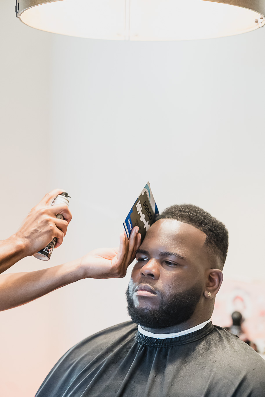 Editorial black and white photo of a groom getting a fresh haircut before his Castle Farms wedding in Northern Michigan. Captured by Kari Dawson + Co, this timeless moment highlights intentional wedding morning details and refined style.”