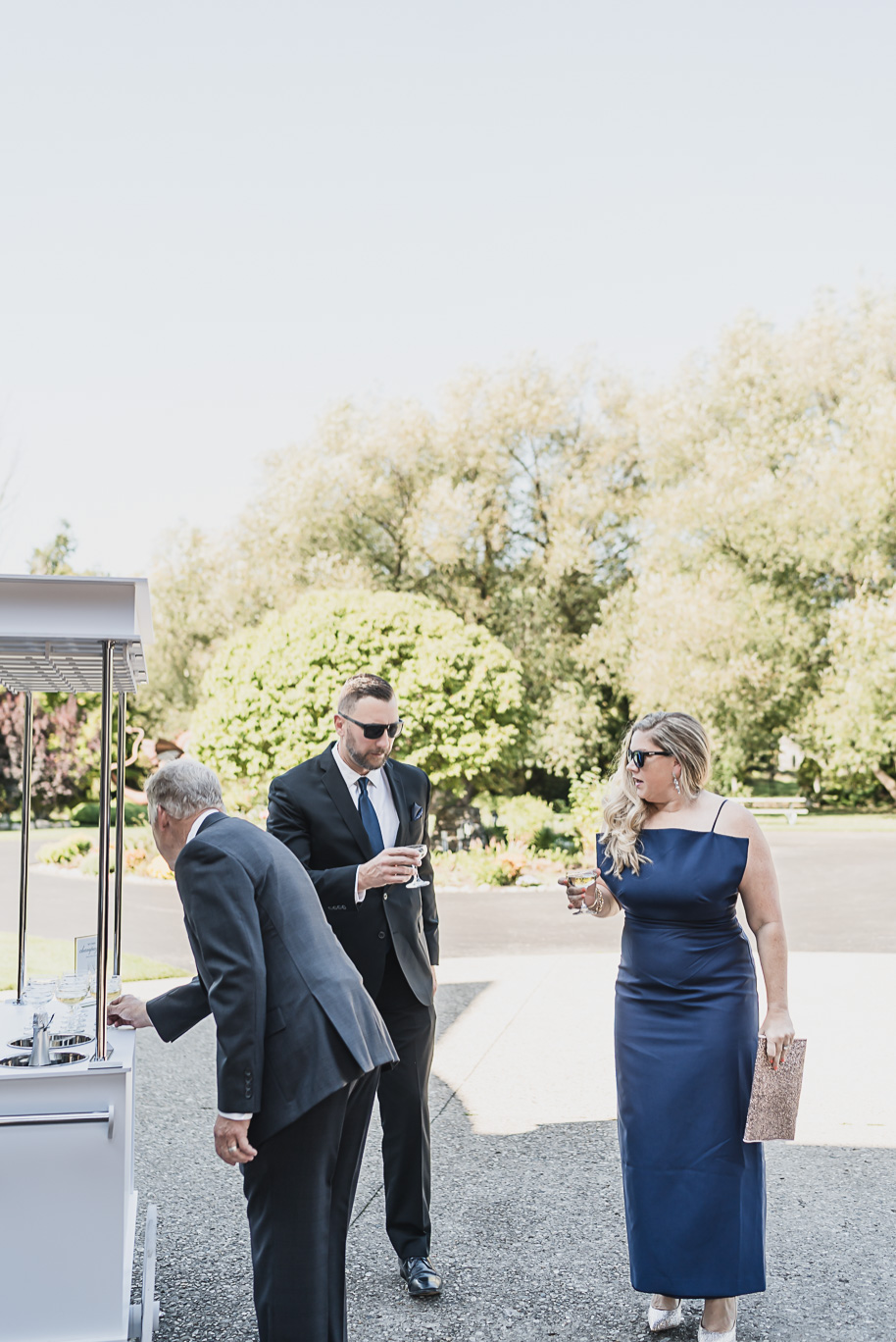 “Guests enjoy champagne from a mobile cart before the ceremony at Castle Farms in Charlevoix, Michigan. Editorial wedding photography by Kari Dawson + Co capturing elevated cocktail hour details and timeless guest style.