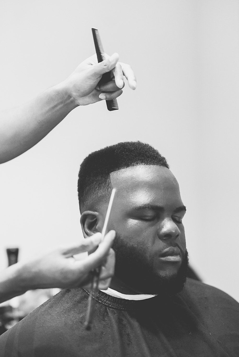 Editorial black and white photo of a groom getting a fresh haircut before his Castle Farms wedding in Northern Michigan. Captured by Kari Dawson + Co, this timeless moment highlights intentional wedding morning details and refined style.