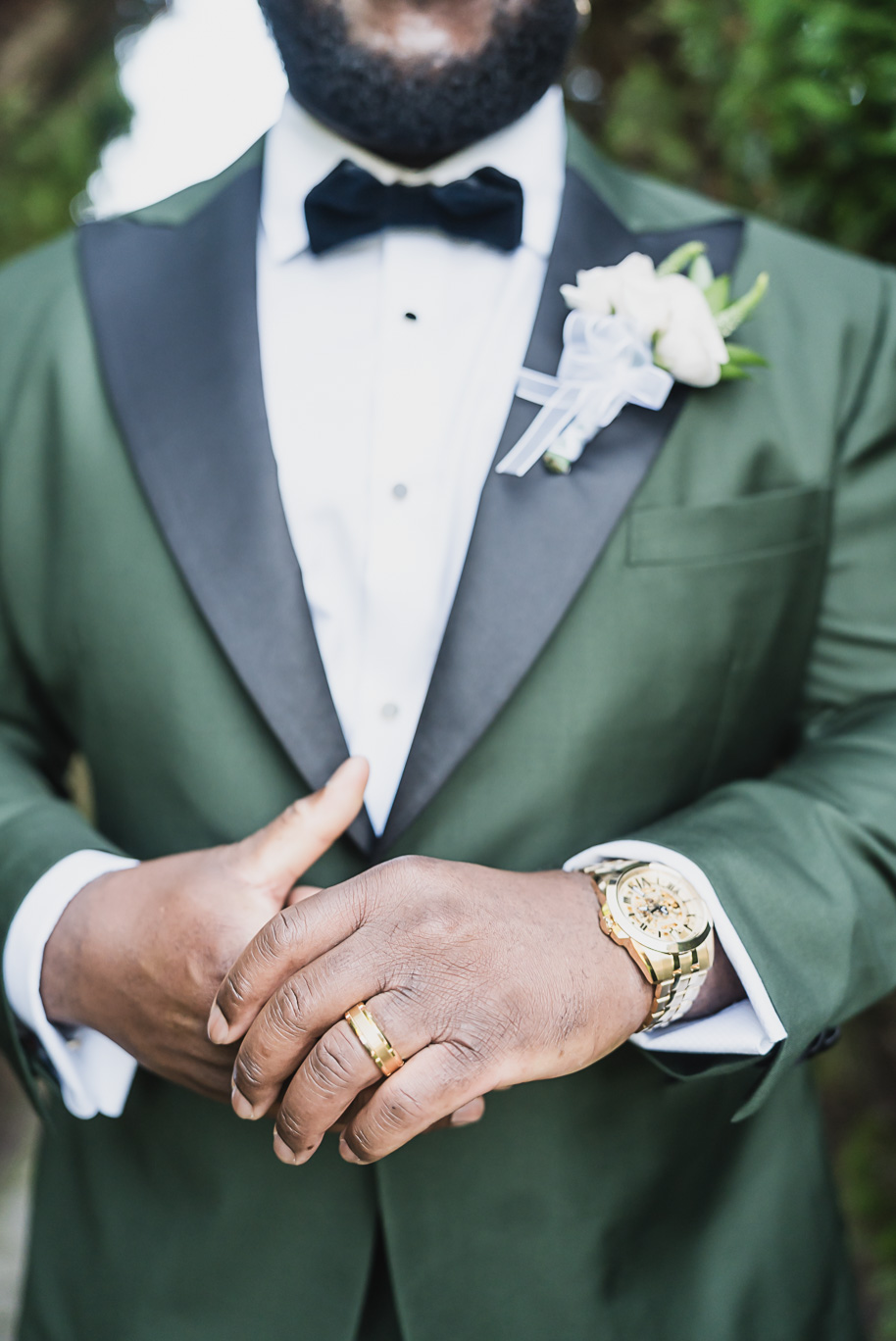 A custom emerald tuxedo worn by the groom for his An emerald and gold fall interracial Castle Farms wedding in Charlevoix Northern Michigan by top-rated Northern Michigan wedding photography team Kari Dawson + Co.
