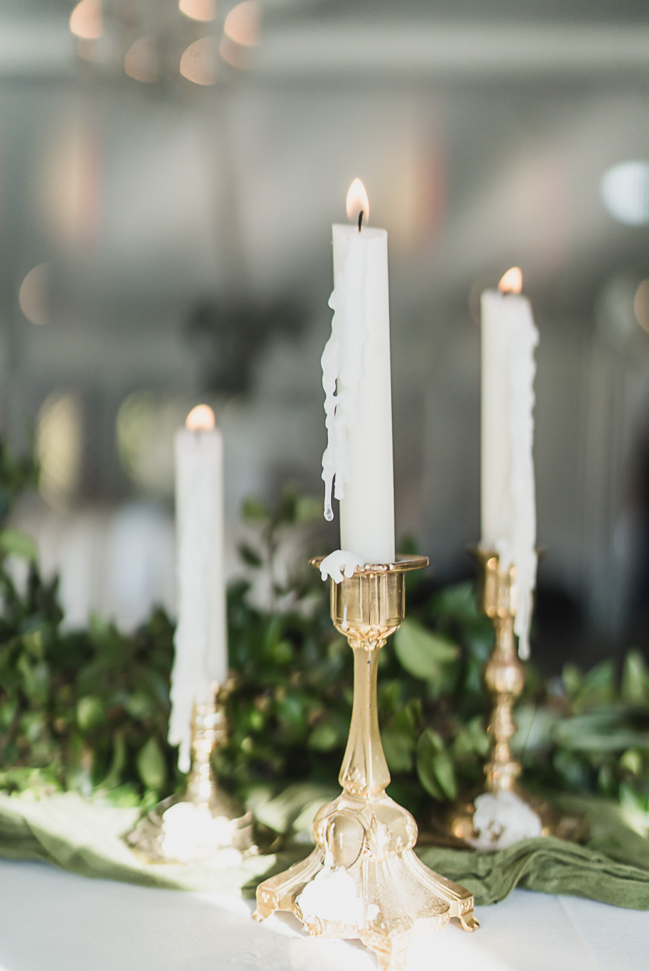 “Elegant gold candlesticks with softly melted taper candles at a Castle Farms wedding reception in Northern Michigan. Captured by Kari Dawson + Co, this romantic detail shot reflects timeless luxury and refined wedding decor inspiration.