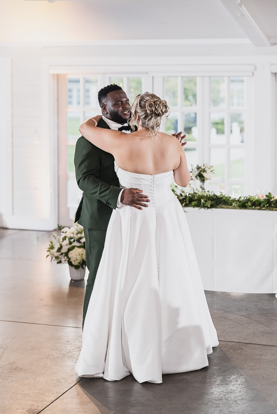 Bride and groom share their first dance during a Castle Farms wedding reception in Northern Michigan. Captured by Kari Dawson + Co, this emotional moment highlights the couple’s joyful connection, elegant attire, and the soft, romantic lighting of their luxury celebration.