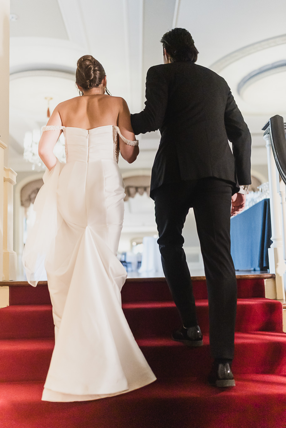 Bride and groom see the complete reception space before guests enter. Classic Lovett Hall reception setup with chandeliers, round tables, and timeless white floral centerpieces.