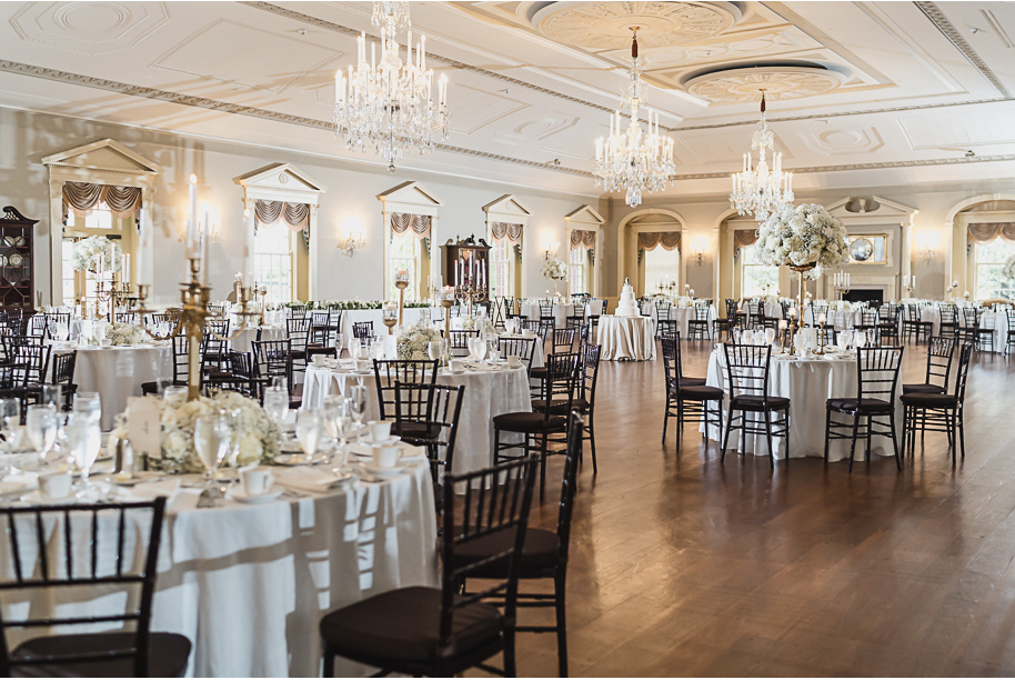 Classic Lovett Hall reception setup with chandeliers, round tables, and timeless white floral centerpieces.