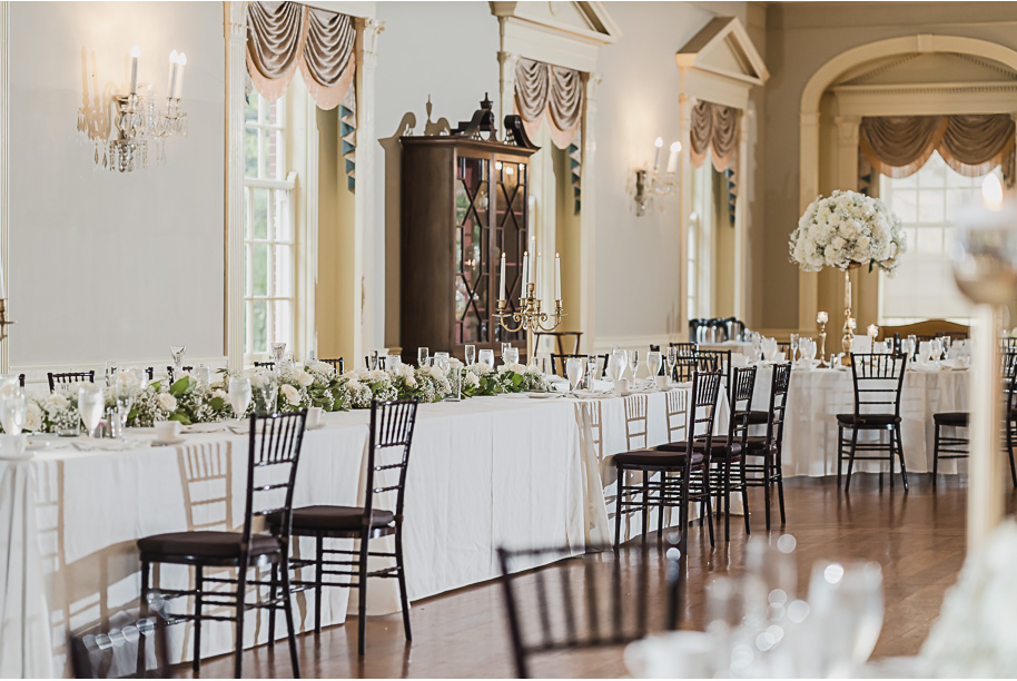 Classic Lovett Hall reception setup with chandeliers, round tables, and timeless white floral centerpieces.