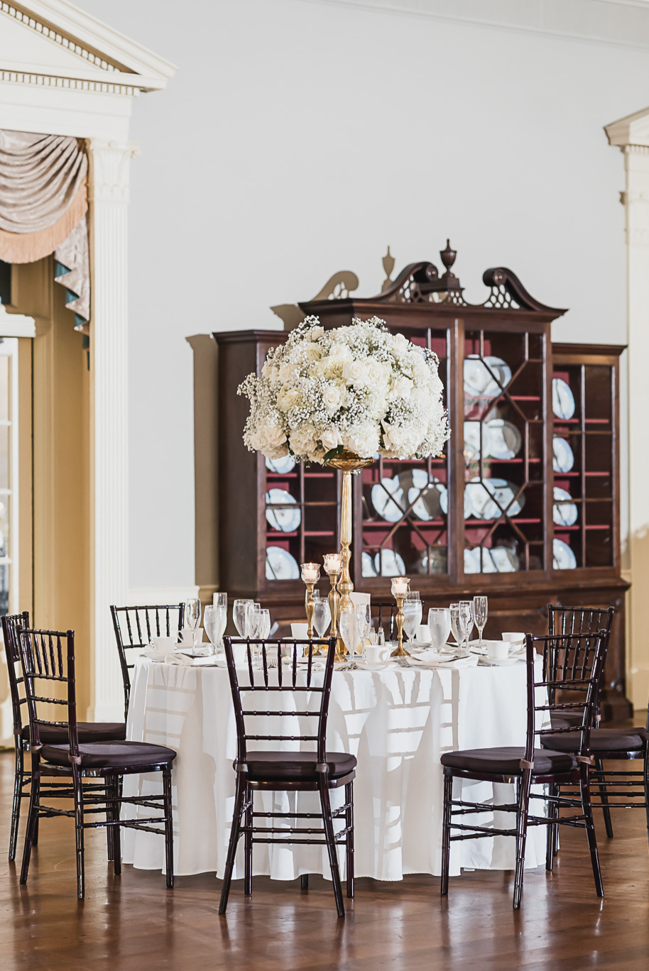 Elegant white rose and baby’s breath centerpiece with table number card at Lovett Hall wedding reception.