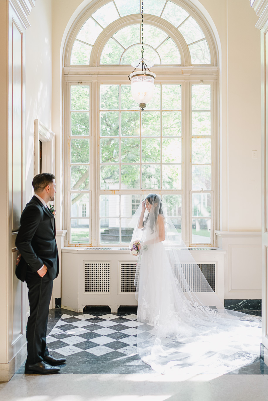A groom loses his breath when he sees his wife posing in her couture wedding gown at the Henry Ford Museum in Dearborn, MI. 